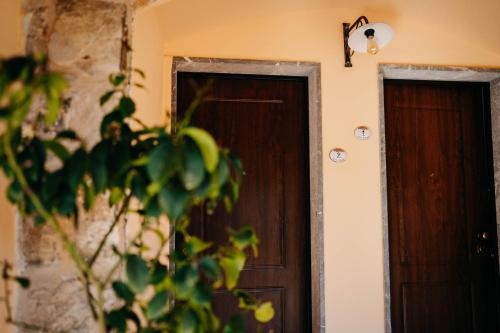a wooden door in a room with a plant at Tenuta Le Tre Rose in Vibonati