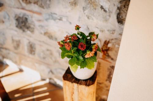 a vase with flowers sitting on top of a wooden stump at Tenuta Le Tre Rose in Vibonati