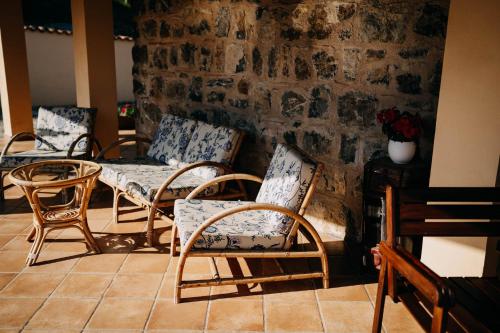 a group of chairs and tables against a brick wall at Tenuta Le Tre Rose in Vibonati