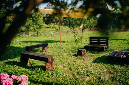 a park with two benches and an umbrella and flowers at Tenuta Le Tre Rose in Vibonati