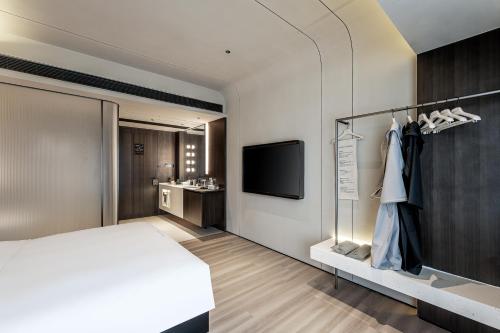 a hotel room with a bed and a tv at NOA Hotel Shanghai- Jing'an Temple in Shanghai