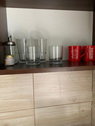 a row of measuring cups sitting on top of a wooden shelf at Panda apartman in Esztergom