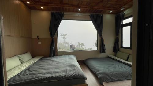 a bedroom with two beds and a window at Mountain Nest Villa Dalat - BBQ, Cloud Hunting, Camping in Da Lat