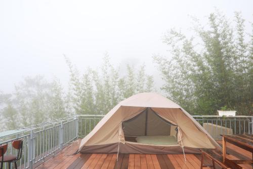 a tent sitting on a deck with trees in the background at Mountain Nest Villa Dalat - BBQ, Cloud Hunting, Camping in Da Lat