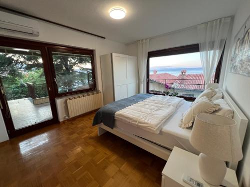 a bedroom with a large bed and a large window at Villa Maris Izola in Izola