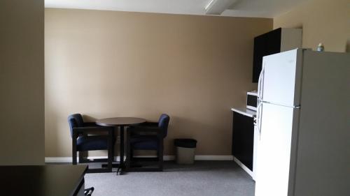 a kitchen with a table and chairs and a refrigerator at Chinook Country Inn in Sundre