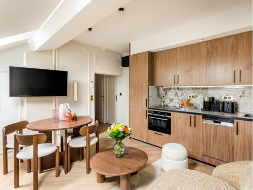 un salon avec une table et une cuisine dans l'établissement Merveil - Luxury Suite - Champs Elysees - St Cyr I, à Paris