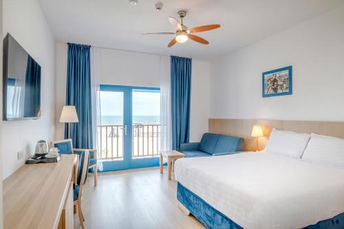 ein Hotelzimmer mit Bett und Balkon in der Unterkunft Gura Portitei Resort in Jurilovca