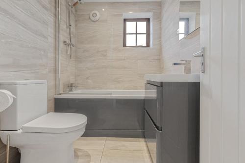 a bathroom with a toilet and a sink and a tub at Quaint house - PARKING GARDEN in Brighton & Hove
