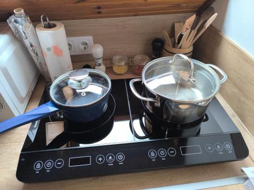two pots and pans sitting on top of a stove at CsillaG Apartman in Kisapáti