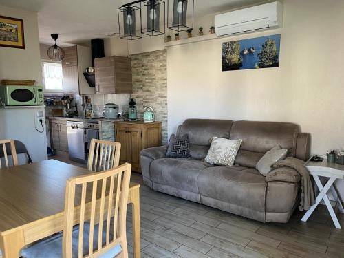 un salon avec un canapé et une table et une cuisine dans l'établissement Cœur de sousto, à Six-Fours-les-Plages