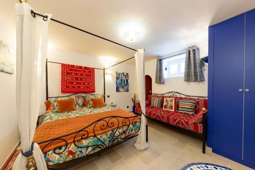 une chambre avec un lit à baldaquin et un canapé dans l'établissement Les Jardins de Marrakech Super centre, à Cannes