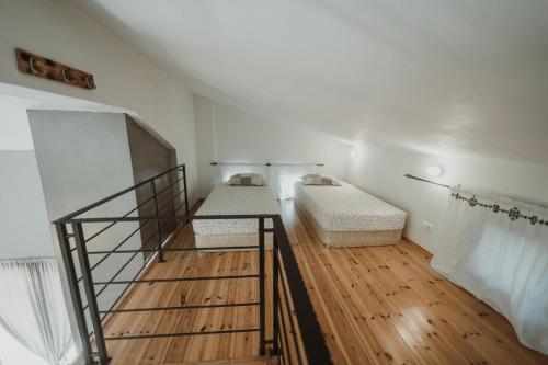 a room with two beds and a wooden floor at Ktima Papadopoulou in Krionérion