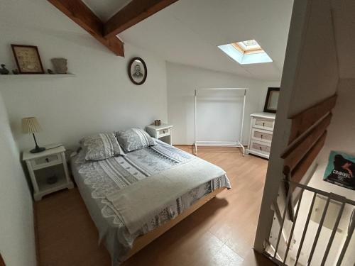 une chambre avec un lit et une horloge au mur dans l'établissement Maison de charme près du lac, à Hourtin