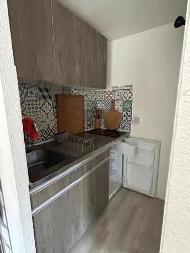 une cuisine avec un évier et un plan de travail dans l'établissement Maison de charme près du lac, à Hourtin