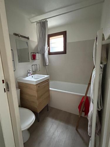 une salle de bain avec un lavabo et des toilettes et une fenêtre dans l'établissement Maison de charme près du lac, à Hourtin