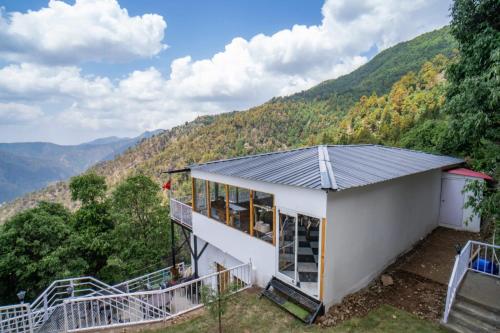 a house with a view of the mountains at Ila by Aaryam, Kanatal in Chamba