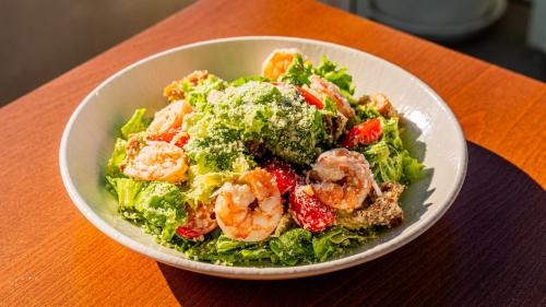 a bowl of salad with shrimp and lettuce on a table at Sky Boutique Hotel in Perea
