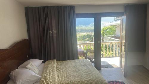 a bedroom with a bed with a view of a balcony at Guesthouse Mele in Gjirokastër