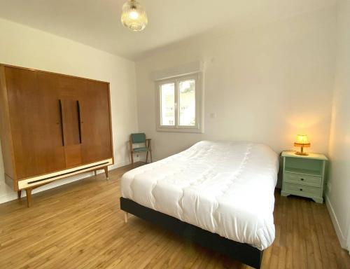une chambre avec un lit, une commode et une fenêtre dans l'établissement Maison avec WIFI, jardin à 320m de la plage à TREGASTEL - Réf 183, à Trégastel