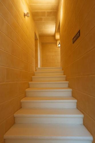 a hallway with white stairs in a building at Traditional Maltese Family Townhouse - Cospicua in Cospicua