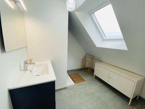 une salle de bain avec un lavabo et une fenêtre dans l'établissement Maison avec WIFI, jardin à 320m de la plage à TREGASTEL - Réf 183, à Trégastel