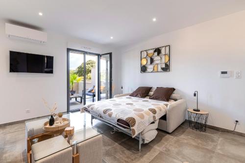 une chambre avec un lit et une télévision dans l'établissement Les Vagues d'Agosta, à Albitreccia