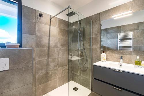 une salle de bain avec douche et lavabo dans l'établissement Les Vagues d'Agosta, à Albitreccia