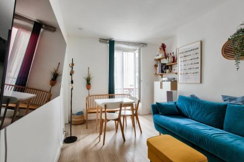 un salon avec un canapé bleu et une table dans l'établissement Charmant appart cosy et central, à Paris