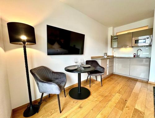 Zimmer mit einem Tisch mit 2 Stühlen und einer Lampe in der Unterkunft Balkon und Eleganz Düsseldorf in Düsseldorf