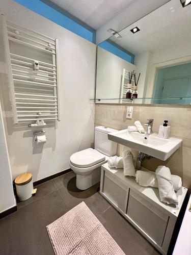 ein Badezimmer mit Waschbecken, Toilette und Spiegel in der Unterkunft Balkon und Eleganz Düsseldorf in Düsseldorf