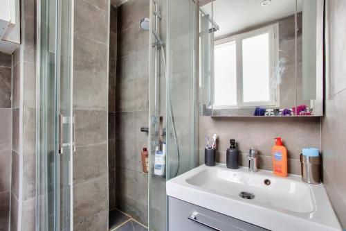 une salle de bain avec un lavabo et une douche dans l'établissement Charmant appart cosy et central, à Paris