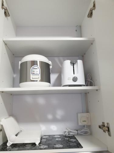 a coffee maker and a toaster sitting on shelves at Arte Mont Kiara Studio,Kuala Lumpur in Kuala Lumpur