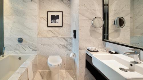 a bathroom with a sink and a toilet and a tub at Marco Polo Xiamen in Xiamen