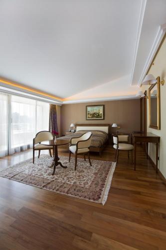 a living room with a bed and a table and chairs at Monte Casa SPA & Wellness in Petrovac na Moru