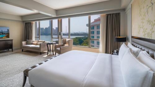 a hotel room with a large bed and a large window at Marco Polo Xiamen in Xiamen