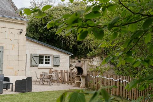 une terrasse avec un four à pizza à côté d'une maison dans l'établissement Gîte Les Caves aux Fièvres - Maison avec jardin près de Chinon, à Beaumont-en-Véron