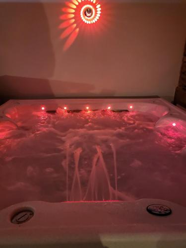 - un bain à remous avec des lumières rouges dans la chambre dans l'établissement Gîte romantique Le GLAMOUR, à Mazé