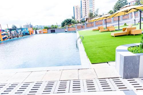 a swimming pool on a building with tables and chairs at Greenland Premium Apartments in Kigali