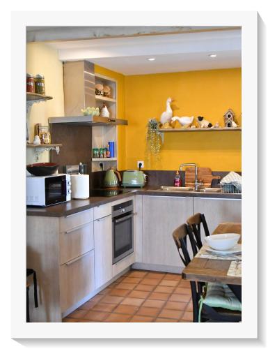 une cuisine avec un évier et une table à l'intérieur dans l'établissement La belle provençale, à Saint-André-de-Roquepertuis