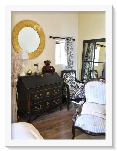 une chambre avec une commode, une chaise et un miroir dans l'établissement La belle provençale, à Saint-André-de-Roquepertuis