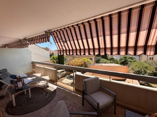 un balcon avec une pièce avec des chaises et une table dans l'établissement A 200m des plages grand studio ouvrant sur très large terrasse, à Juan-les-Pins