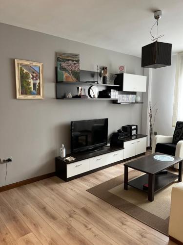 a living room with a flat screen tv on a wall at Apartamentos Tajamar in Lastres