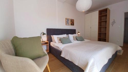 a bedroom with a bed and a chair in it at Apartments Daria in Krk