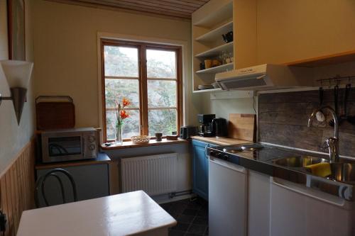 a small kitchen with a sink and a window at Lägenhet med fri parkering in Nynäshamn