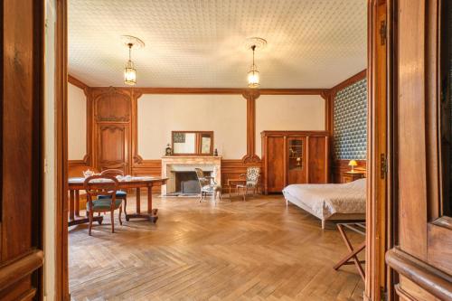 une chambre avec un lit et une table dans une pièce dans l'établissement Chambres au Chateau Saint-geoire, à Saint-Geoire-en-Valdaine