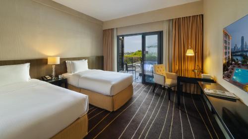 a hotel room with two beds and a balcony at Marco Polo Xiamen in Xiamen