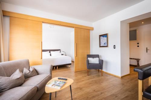 a living room with a couch and a bed at Hotel Berghof in Seefeld in Tirol