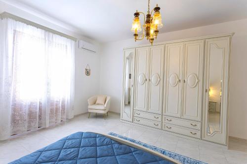 a bedroom with a large white cabinet and a chandelier at Art House - Big & Artistic Design House in Minervino di Lecce
