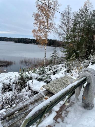 a hose in the snow next to a body of water at Stuga med egen brygga in Fagersta